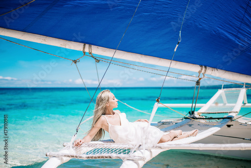 beautiful bride on wedding day ready for travel by sail boat.