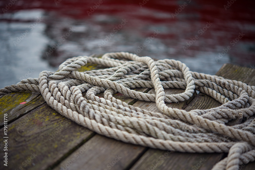 Old ship rope on a wooden obsolete pier