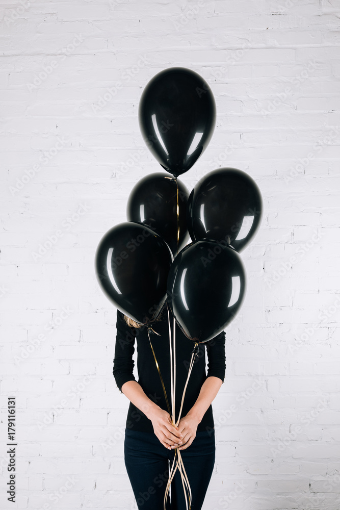 woman holding black balloons woman holding black balloons