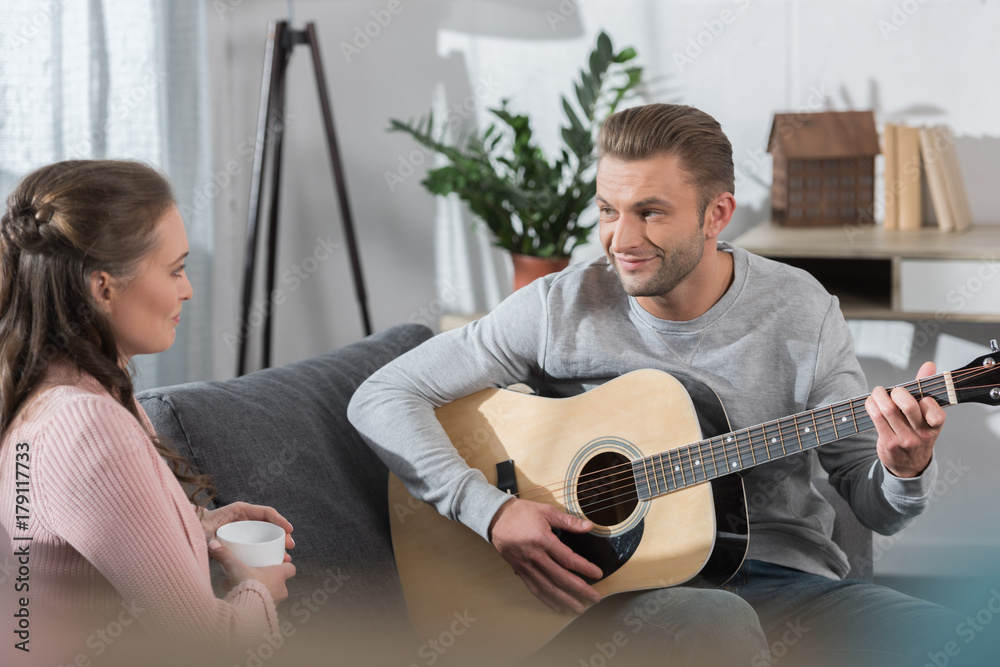 Obraz premium Boyfriend playing guitar to girlfriend