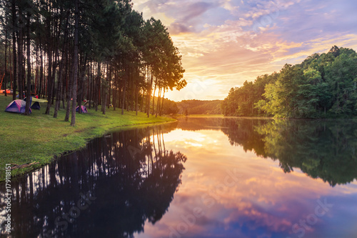 Sunrise in early morning at pang ung lake in mae hong son,Thailand with pine trees reflection on the water selective soft focus