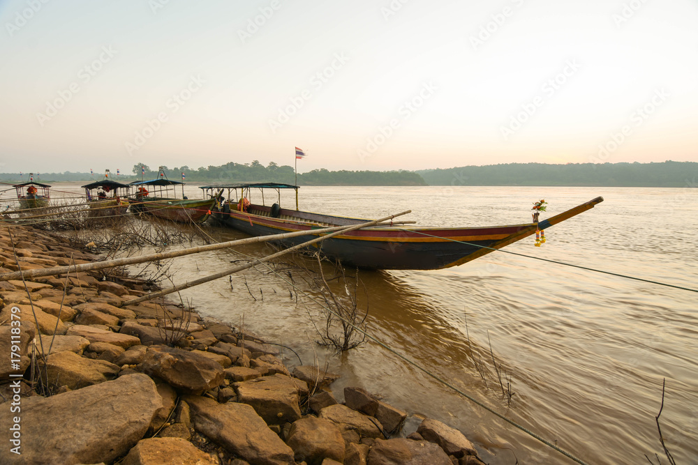 Passenger boat crossing the Thai-Laos border with the Thai flag on the Mekong River at dawn.
Passenger boat crossing the Thai-Laos border with the Thai flag on the Mekong River at dawn.
