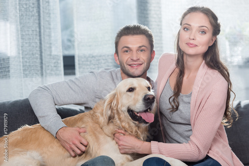 couple on couch petting dog