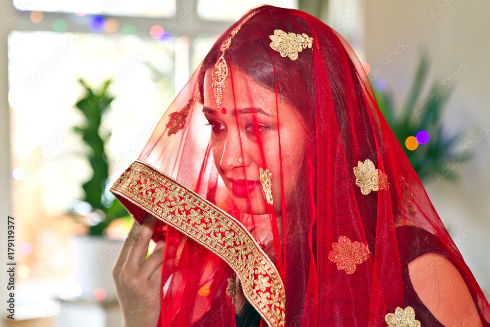 Asian Hindu bride covers her face with a veil. Hindu Bride