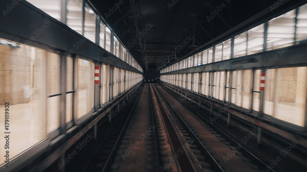 View of subway tunnel as seen from the rear window of moving train. Fast underground train departs from modern subway station. View of subway tunnel as seen from the rear window of moving train. Fast underground train departs from modern subway station.
