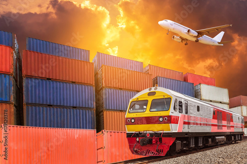      Global business with commercial cargo freight train and container cargo stack at the dock during cargo plane flying above on sunset time. logistics transportation delivery import export concept.
