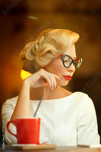 Sexy blonde in retro look resting in cafe