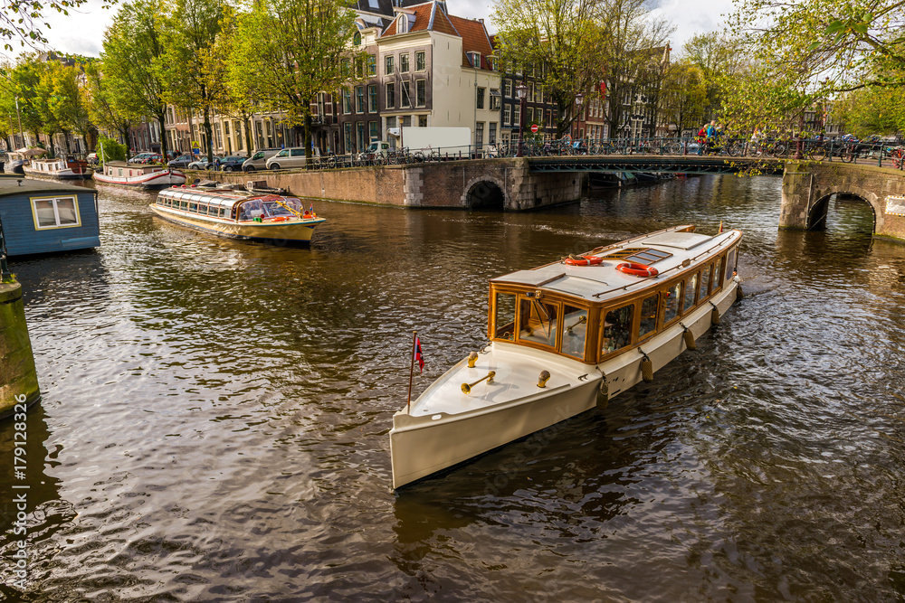 Naklejka premium Canal à Amsterdam et ses vedettes touristiques, Hollande aux Pays-Bas