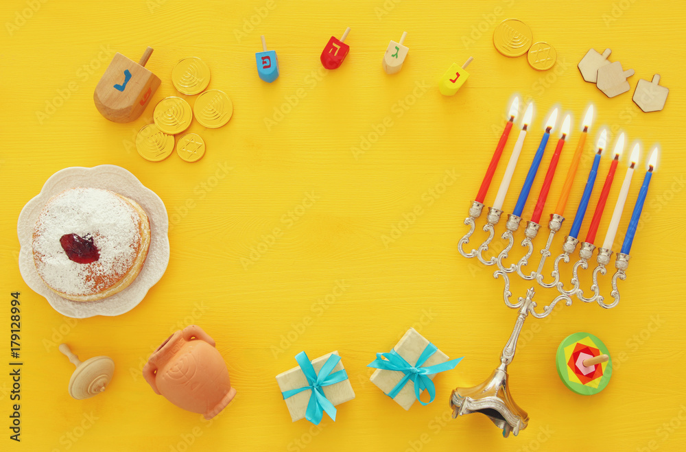 Obraz premium Top view image of jewish holiday Hanukkah background with traditional spinnig top, menorah (traditional candelabra)
