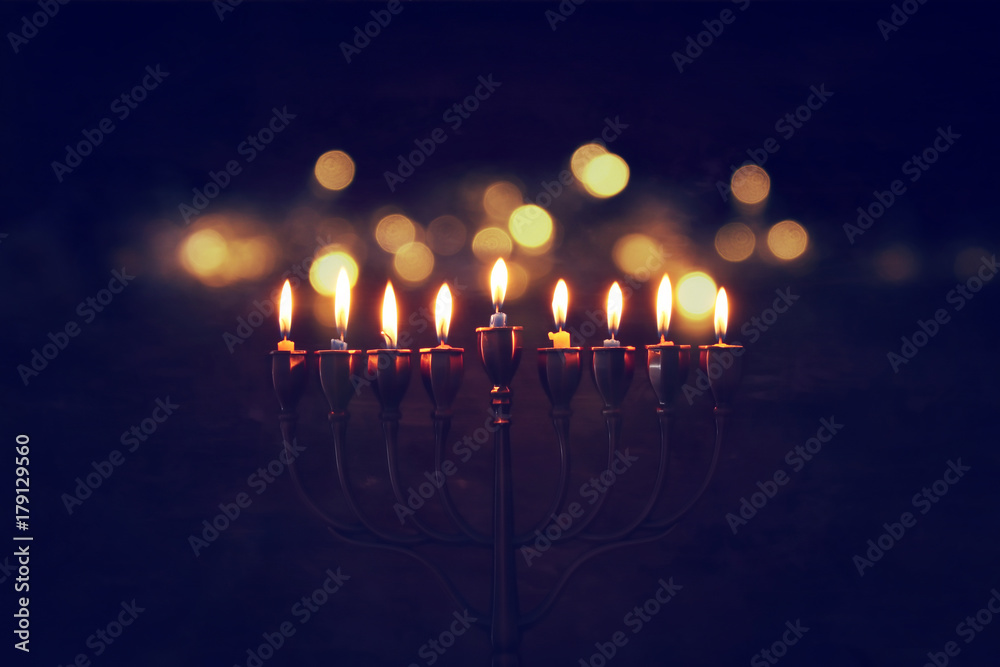 Fototapeta premium Niski klucz obraz tła żydowskiego święta Chanuka z menorą (tradycyjne świeczniki) i płonącymi świecami