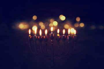 Low key image of jewish holiday Hanukkah background with menorah (traditional candelabra) and burning candles
