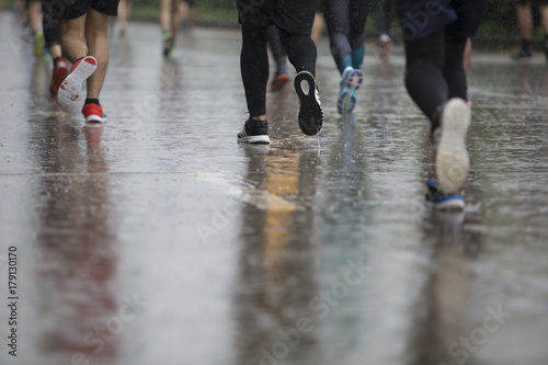 Fototapeta Naklejka Na Ścianę i Meble -  back man Marathon runners focus clear running shoes on the street with rain.