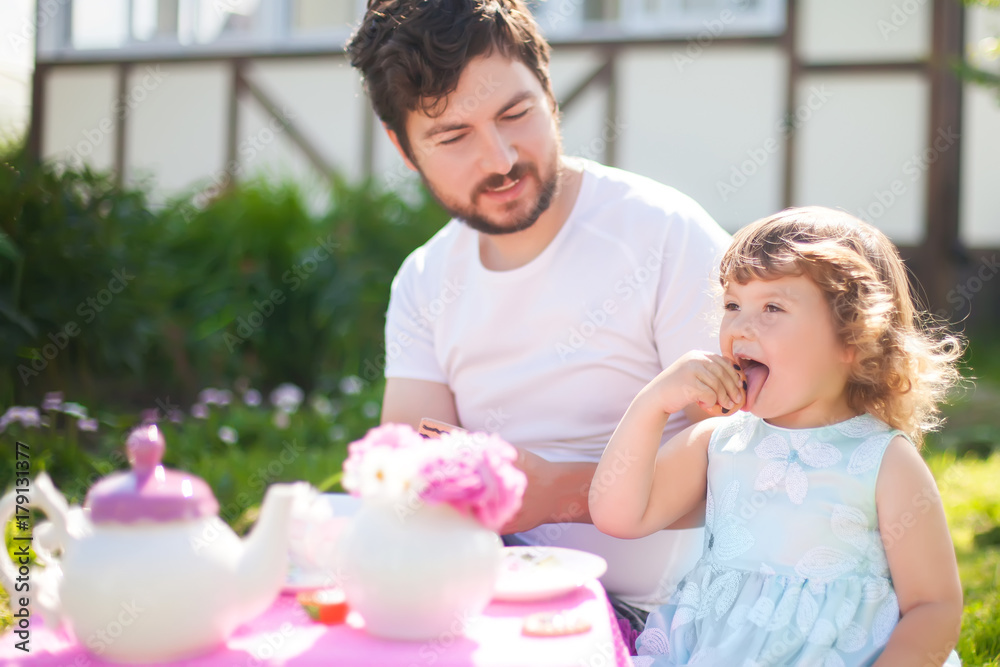 Cute little princess playing tea party with her loving father. Cute little princess playing tea party with her loving father.