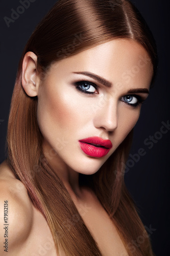 Portrait of beautiful girl model with evening makeup and romantic hairstyle. Red lips