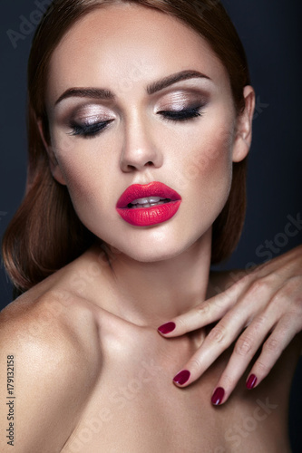 Portrait of beautiful girl model with evening makeup and romantic hairstyle. Red lips