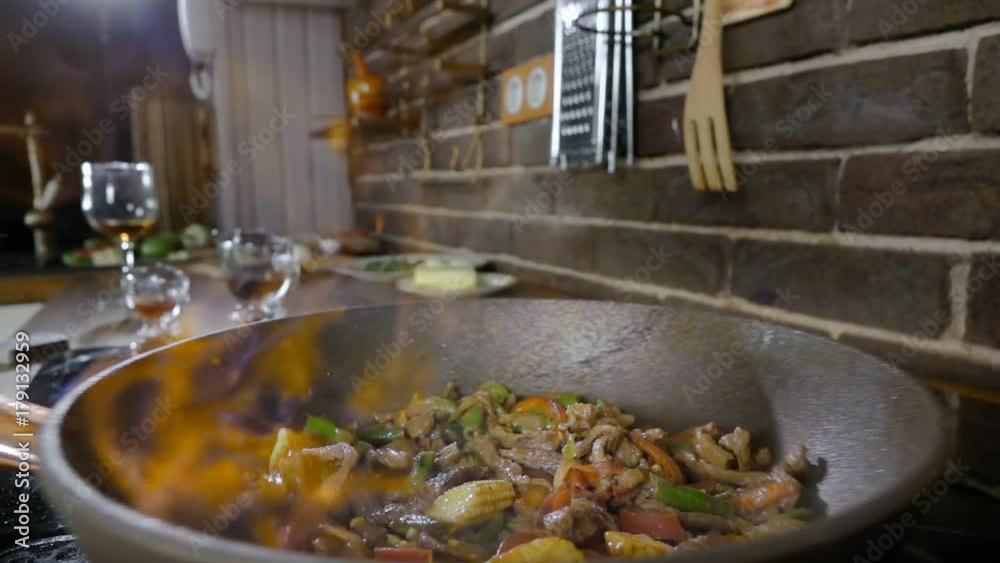 Close-up of a Preparing Flambe Style Dish on a Pan at home. Vegetables, meat, and Alcohol Ignite with Open Flames. Slow motion Close-up of a Preparing Flambe Style Dish on a Pan at home. Vegetables, meat, and Alcohol Ignite with Open Flames. Slow motion
