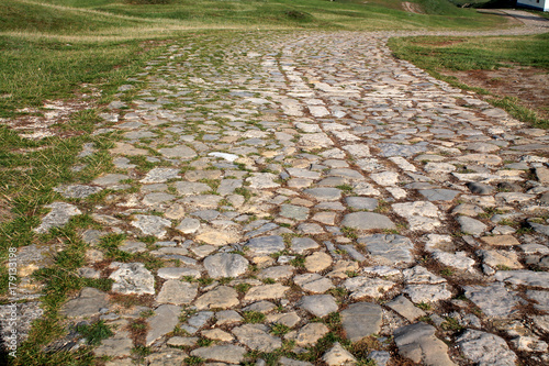 Ancient winding road paved with cobblestone . photo