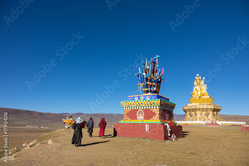 Tibetan monk walking into big Buddha in Yarchen Gar , Baiyu district China © kobackpacko