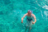 Man with snorkeling mask for diving swimming in the Indian ocean at Maldivian island. Man is snorkeling in the tropical sea. Happy man Enjoying snorkelling with clear blue water in the Maldives ocean.