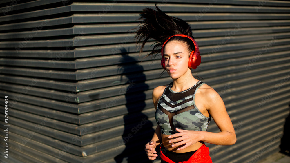 Active young beautiful woman running on in urban area by night Active young beautiful woman running on in urban area by night