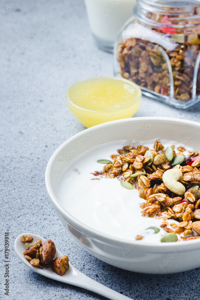 Chewy honey coconut granola yogurt bowl on dark concrete background. Selective focus, copy space. Chewy honey coconut granola yogurt bowl on dark concrete background. Selective focus, copy space.