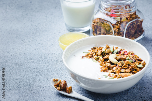 Grain free paleo granola yogurt breakfast  bowl on dark concrete background. Selective focus, copy space.