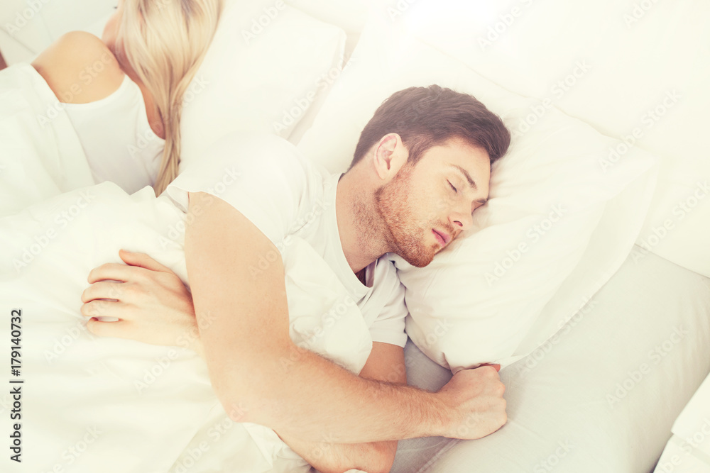 couple sleeping in bed at home couple sleeping in bed at home