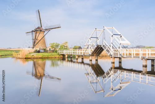 Windmill and sluice on the canal, Kinderdijk, Molenwaard municipality, South Holland province, Netherlands