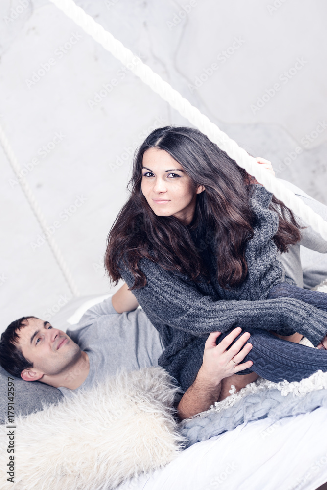Happy Smiling Couple in love. Valentine's day. Winter portrait. Handsome young man and beautiful woman on a date spending time together at home scandinavian style. Romance, family and love concept. Happy Smiling Couple in love. Valentine's day. Winter portrait. Handsome young man and beautiful woman on a date spending time together at home scandinavian style. Romance, family and love concept.