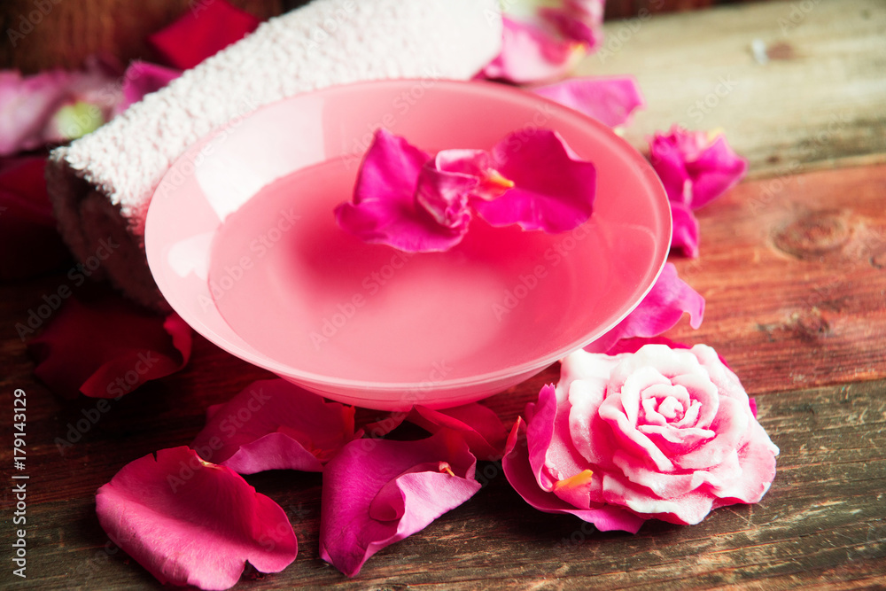 Spa setting with rose pink flowers and petals,bath salt and body-oil Spa setting with rose pink flowers and petals,bath salt and body-oil