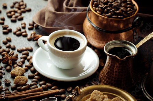 Black coffee in a cup on the table in a composition with coffee accessories on an old background © vizafoto