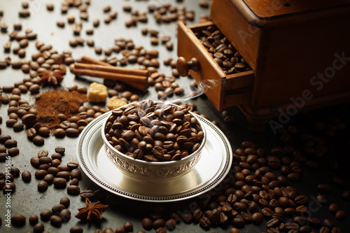 Black coffee in a cup on the background of coffee beans in a composition with accessories