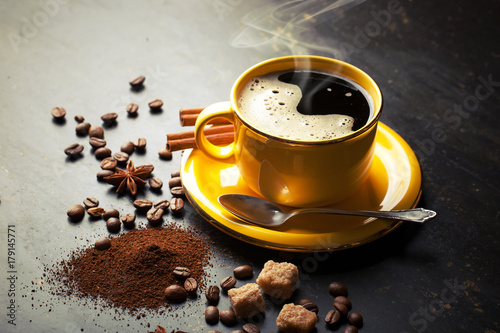 Black coffee in a cup on the background of coffee beans in a composition with accessories photo