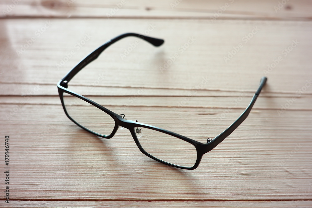 Black eyeglasses on wood plate. Black eyeglasses on wood plate.