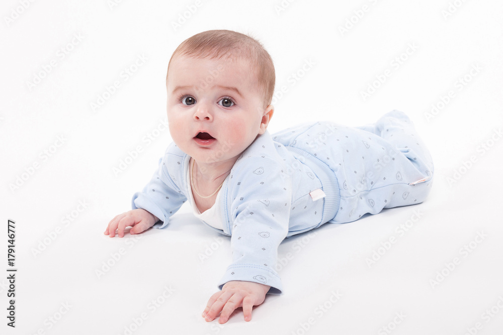 baby in the body lying on his stomach on a white background and looking at the camera baby in the body lying on his stomach on a white background and looking at the camera