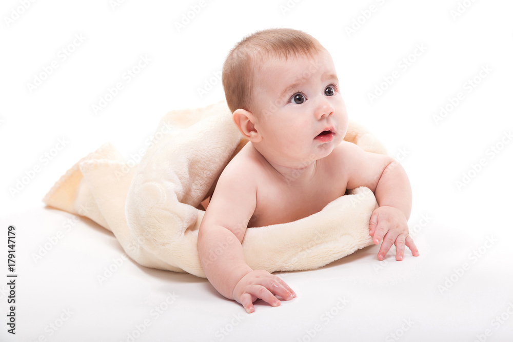 Naked smiling baby lying on his stomach on a white background and looking at the camera Naked smiling baby lying on his stomach on a white background and looking at the camera