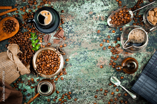 Black coffee in a cup on the background of coffee beans in a composition with accessories