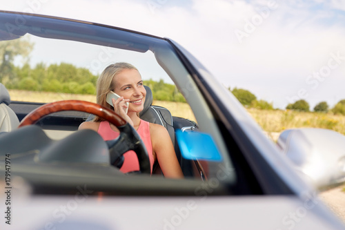 woman calling on smartphone at convertible car
