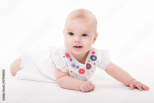 Baby girl on a white background in a smart dress