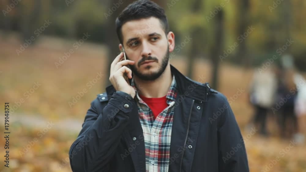 handsome bearded young man talking phone mobile confident serious calm face app business administration negotiation discussion agreement autumn beautiful park blur background argument businessman male handsome bearded young man talking phone mobile confident serious calm face app business administration negotiation discussion agreement autumn beautiful park blur background argument businessman male