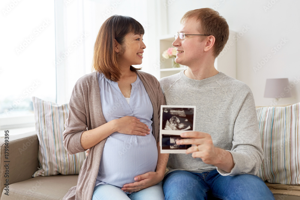 happy couple with ultrasound images at home happy couple with ultrasound images at home