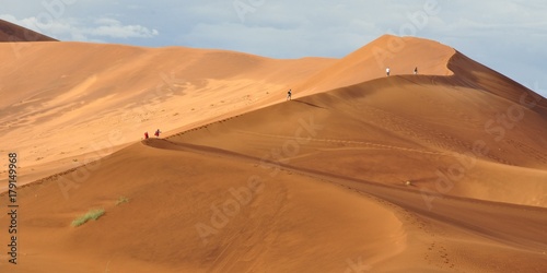 Sand dune in Sossusvlei, Namibia. People walking the rim.