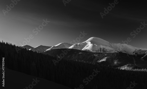 Black and white landscape of a mountain range covered with snow. photo