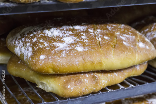 Many ready-made fresh bread in a bakery oven in a bakery. Bread making business. Soft focus