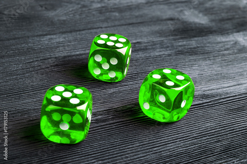 risk concept - playing dice at black wooden background. Playing a game with dice. Green casino dice rolls. Rolling the dice concept for business risk  chance  good luck or gambling