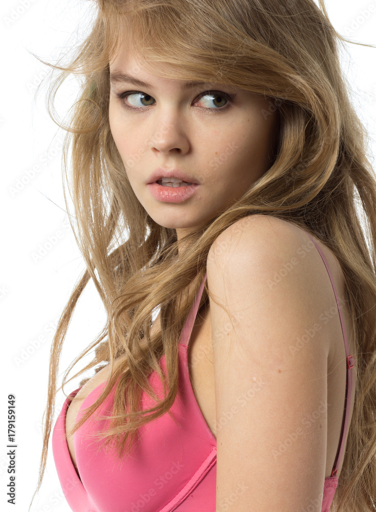 Beautiful blond young woman in a pink dress looks to the side. Isolated on white. Beautiful blond young woman in a pink dress looks to the side. Isolated on white.