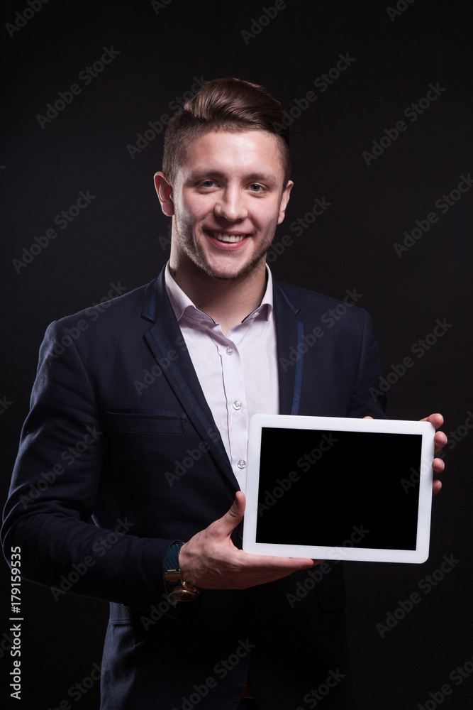 Picture of serious businessman standing with tablet Picture of serious businessman standing with tablet