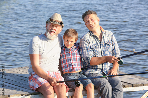 Family fishing on pond toge...