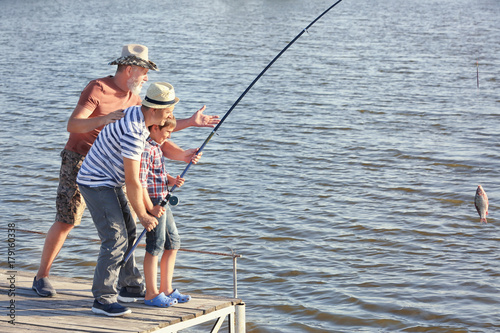 Family fishing on pond toge...