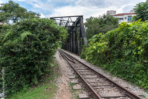 View along the railway. Old railroad across the bridge. The road for the train on the sides of the green vegetation and forest